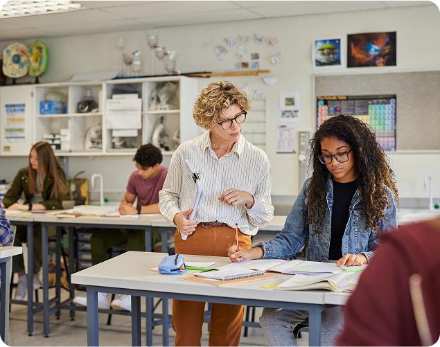 Teacher guiding student in classroom